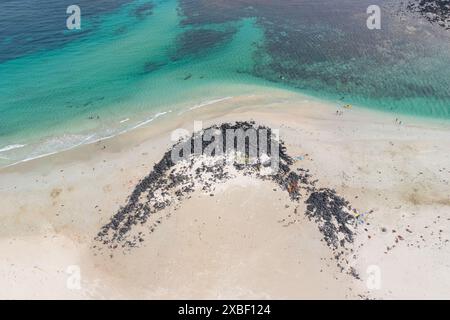 Aus der Vogelperspektive auf eine felsige Barriere an einem weißen Sandstrand neben türkisfarbenem Wasser bei Port Fairy an der Great Ocean Road in Victoria, Australien Stockfoto