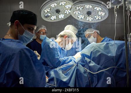 Chirurgen, die im Operationssaal unter hellem Licht operieren Stockfoto