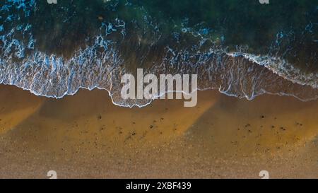 Aus der Vogelperspektive: Abgeschiedener Strand, ruhige Meereswellen. Stockfoto