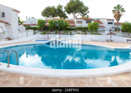 Wohnpool in einem modernen Wohnkomplex mit klarem blauem Wasser und umliegendem Grün Stockfoto