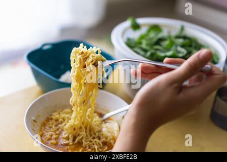 Eine Person isst Instant Nudel mit einer Gabel Stockfoto