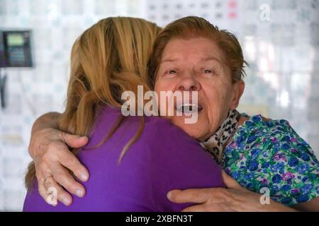 Mutter und Tochter umarmen sich in der Küche. Familienzeit Stockfoto