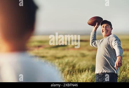 Kinder, Männer und Fußball mit Werfen in der Natur für Outdoor-Abenteuer, Unterricht und Kinderentwicklung. Happy, Dad und Sport mit Sohn auf dem Grasfeld für Stockfoto