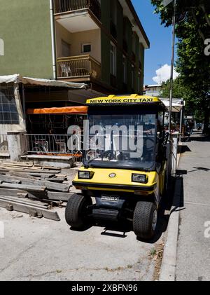 Italien, Rimini, 12. juni 2024 - gelbes Melex Elektroauto in italienischer Stadt Stockfoto