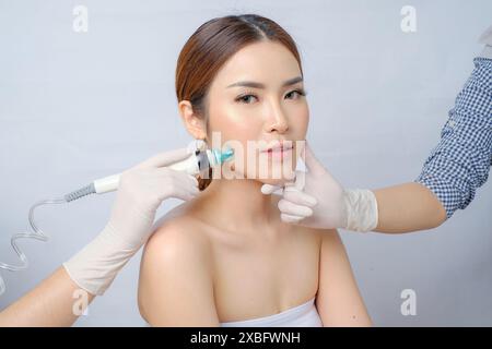 Entzückende asiatische Frau in SilkPeel Gesichts Sitzung für Haut Gesundheit Stockfoto