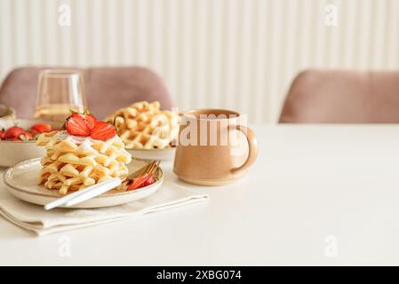 Belgische Waffeln mit Erdbeeren und Puderzucker auf weißem Tisch. Sommer-Food-Konzept. Weichzeichner Stockfoto