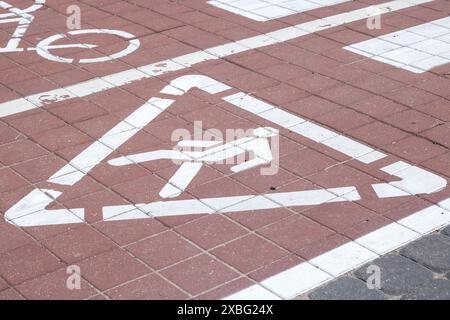 Auf dem gemauerten Pflaster befindet sich ein Schild für Fußgänger, das häufig auf Straßen zu sehen ist, um einen bestimmten Bereich anzuzeigen, in dem Fußgänger sicher überqueren können Stockfoto