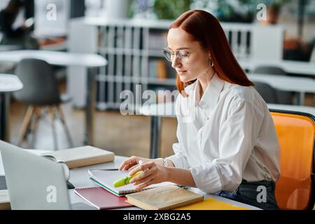 Eine engagierte rothaarige Tutorin unterrichtet online mit einem Laptop nach dem Schulunterricht. Stockfoto