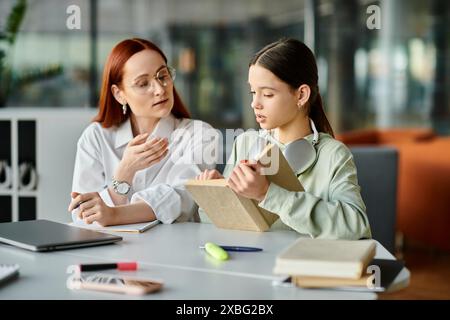 Eine rothaarige Frau unterrichtet ein Teenager-Mädchen an einem Tisch, wo sie nach der Schule unterrichtet. Stockfoto