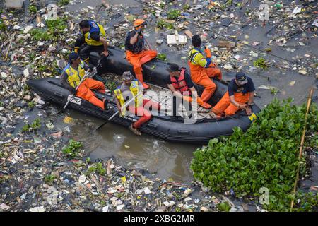 Offiziere, die Holzboote benutzen, beseitigen Plastikmüll, der sich am 12. Juni 2024 im Citarum River in Batujajar, West Bandung Regency, West Java, Indonesien angesiedelt hat. Auf der Grundlage des Umwelt- und Hygienedienstes der Westprovinz, Aufzeichnungen über Abfälle, die seit Freitag, dem 7. Juni 2024 im Gebiet des Citarum Batujajar im Fluss stecken geblieben sind, die 3 Kilometer lange und 60 Meter breite Menge an Kunststoffabfällen könnte schätzungsweise mehr als 100 Tonnen erreichen. (Foto: Dimas Rachmatsyah/SIPA USA) Stockfoto