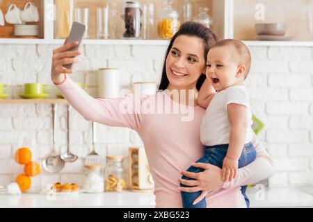 Frau, Die Selfie Mit Baby Nimmt, Kücheneinrichtung Stockfoto
