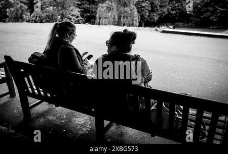 Leute sitzen auf einer Bank in den Princes Street Gardens in Edinburgh, Schottland Stockfoto
