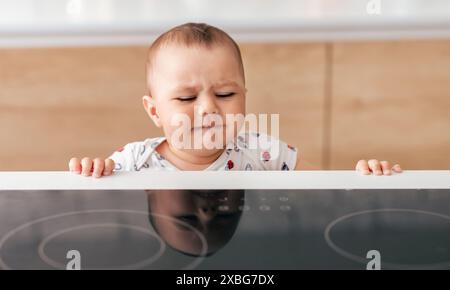 Weinendes Baby, das eine Küchenarbeitsplatte anstarrt Stockfoto