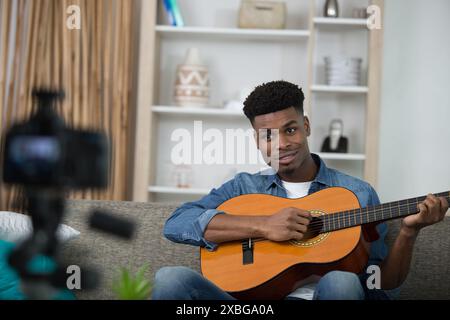 Ein junger gutaussehender Kerl spielt Gitarre Stockfoto