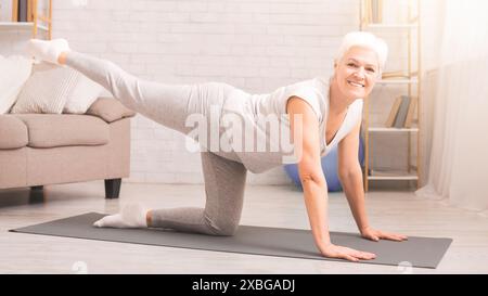 Frau übt Yoga-Pose im Wohnzimmer Stockfoto