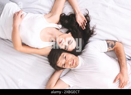Paare, Die Zusammen Im Bett Liegen, Tragen Weiße Hemden, Ansicht Oben Stockfoto