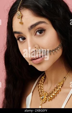 Eine junge indianerin zeigt ihre Schönheit mit Goldschmuck und einem Nasenring. Stockfoto