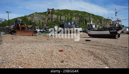 Fischerboote und ein rostiger Bagger am Stade Beach mit East Hill Cliff Railway dahinter. Stockfoto