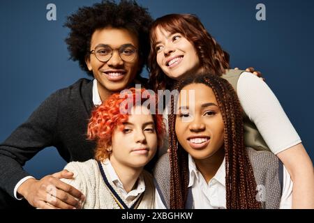 Multikulturelle Freunde, einschließlich einer nicht binären Person, posieren stilvoll in trendiger Kleidung auf einem dunkelblauen Hintergrund. Stockfoto