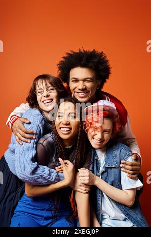 Eine Gruppe junger multikultureller Freunde, einschließlich einer nicht-binären Person, in stilvoller Kleidung, die selbstbewusst für ein Bild zusammenstehen. Stockfoto