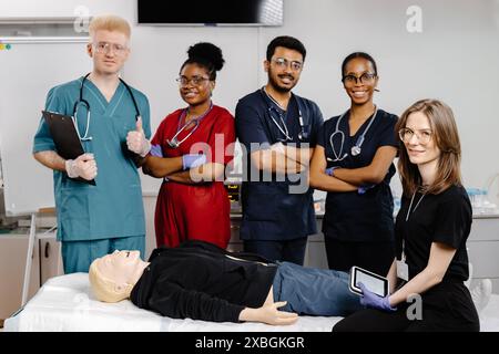 Eine Gruppe von Medizinstudierenden in Scrubs übt während einer ärztlichen Ausbildung die HLW an einer Trainingspuppe. Stockfoto