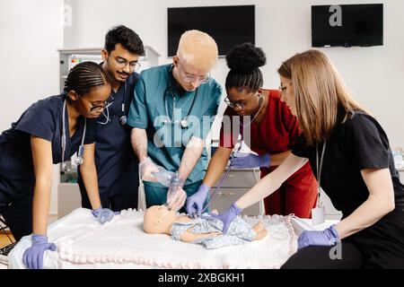 Medizinstudenten in Peelings üben während einer Trainingseinheit die HLW an einer Babypuppe. Stockfoto