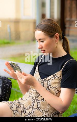 Hübsche Frau, die sich mit Freunden auf einem Videoanruf auf einer Bank unterhält. Stockfoto