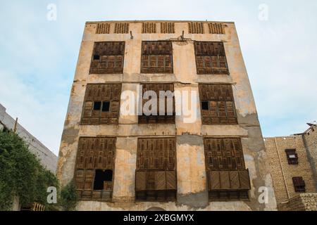 Jeddah, Saudi-Arabien - 12. Dezember 2022: Ein historisches Gebäude im Al-Balad-Viertel mit traditionellen Holzgitterfenstern und verwitterter Fassade Stockfoto