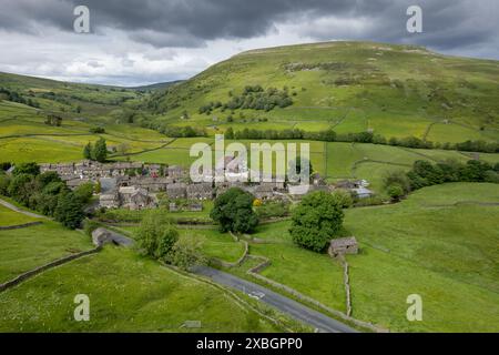 Weiler Thwaite in der Nähe des Kopfes von Swaledale, im Frühsommer, mit Kisdon Hill, der die Skyline dahinter dominiert. Yorkshire Dales National Park, Großbritannien. Stockfoto