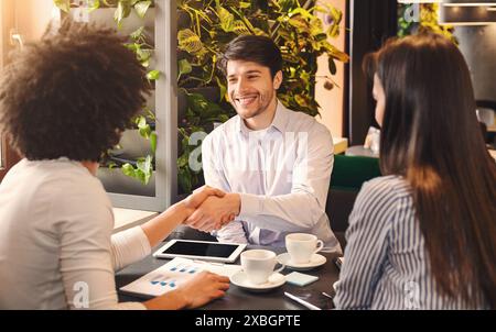 Handschlag von Geschäftsleuten während der Mittagspause im Café Stockfoto