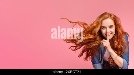 Eine junge Frau mit fließenden roten Haaren, die für Stille gestickt hat Stockfoto