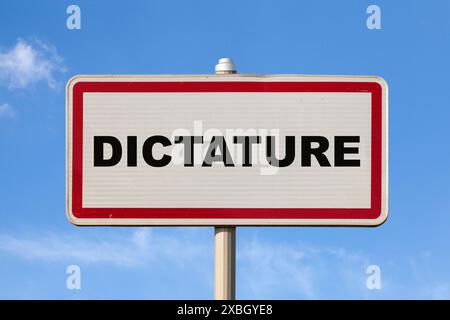 Ein französisches Einreisezeichen vor einem blauen Himmel mit französischer Schrift „Dictature“, was auf Englisch „Diktatur“ bedeutet. Stockfoto