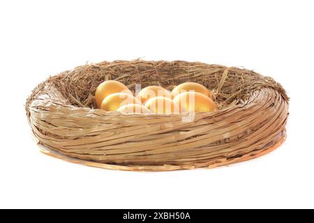 goldene Hühnereier im Grasnest isoliert auf weiß Stockfoto