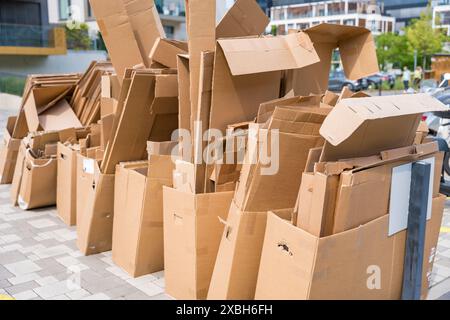 Ein großer Stapel leerer Kartonschachteln, gestapelt und verstreut, der vor einem modernen Gebäude in Prag auf die Recycling-Sammlung wartet. Das Bild wird erfasst Stockfoto