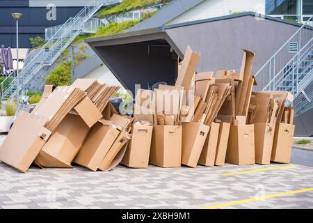 Stapel von Kartonschachteln, die vor dem Parkplatz recycelt werden können. Stockfoto