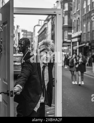 Ein Boris-Johnson-ähnliches öffnet eine Tür in Soho, London. Stockfoto