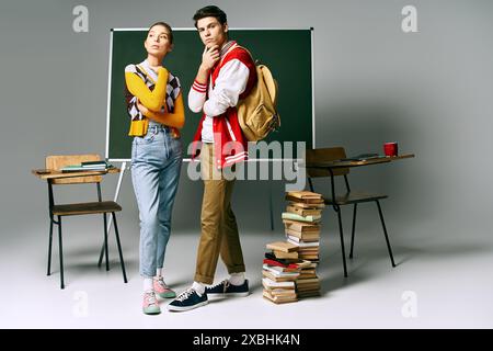 Zwei junge Schüler in lässiger Kleidung stehen vor einem grünen Brett in einem College-Klassenzimmer. Stockfoto