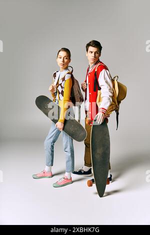 Zwei Jugendliche halten Skateboards vor weißem Hintergrund. Stockfoto