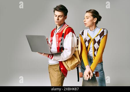Junge Studenten, die zusammen mit einem Laptop in einem College-Klassenzimmer stehen. Stockfoto