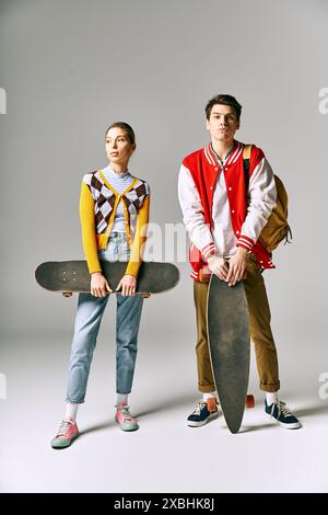 Zwei Jugendliche halten Skateboards vor weißem Hintergrund. Stockfoto