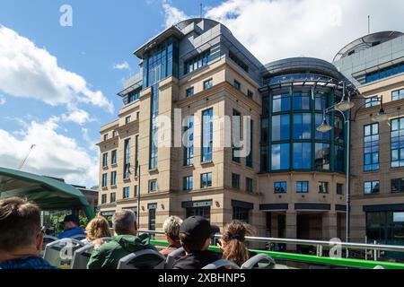 Eine Gruppe von Touristen, die eine Tour im offenen Bus durch Edinburgh genießen, vorbei an der Exchange Plaza Lothian Road, Edinburgh Stockfoto