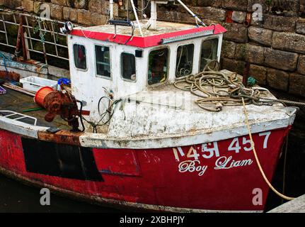 Ein altes, geflicktes Fischerboot im Hafen von Amble, Northumberland, Großbritannien Stockfoto