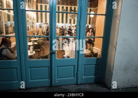 Das ikonische Cafe du Monde im French Quarter von New Orleans, bekannt für seine Beignets und seinen Kaffee, ist voller Gäste, die die lebhafte Atmosphäre genießen. Stockfoto