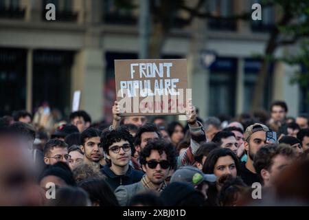 Ein Demonstrant hält während der Demonstration ein Plakat mit der Aufschrift "Front Populaire" (die französische Linke Koalition, die nach den Europawahlen gegründet wurde). Nach dem Sieg Jordaniens Bardellas der Partei Rassemblement National bei den Europawahlen am 9. Juni und dem umstrittenen Beschluss des französischen Präsidenten Emmanuel Macron, die Nationalversammlung aufzulösen, Tausende von Menschen versammelten sich zum dritten Tag in Folge auf dem Place République zu einer massiven Demonstration gegen die extreme Rechte und zugunsten der Front Populaire Koalition, die von den linken Parteien La France Insoumise, dem Sozialisten, gegründet wurde Stockfoto