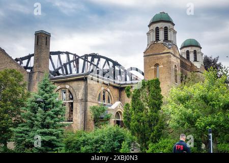 Toronto, Ontario/Kanada - 10. Mai 2024: Offizier der Toronto Fire Services befindet sich außerhalb der verbrannten Überreste der St. Anne's Anglican Church, einer nationalen historischen Stätte Kanadas. Die Kirche wurde durch einen Brand am Morgen des 9. Juni 2024 schwer beschädigt. Der Dom, der von drei Mitgliedern der berühmten Gruppe der Sieben und anderen bedeutenden Künstlern gemalt wurde, ging ebenfalls verloren. Stockfoto