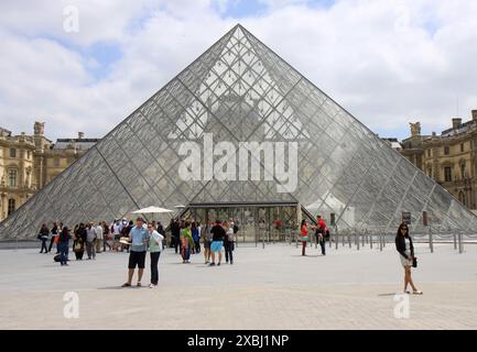 PARIS, FRANKREICH - 17. JUNI 2014: Unbekannte Touristen stehen vor dem Eingang des Louvre-Museums Stockfoto