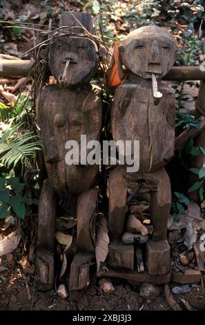 Zwei aus Holz geschnitzte Ahnenfiguren eines Mannes und einer Frau, die beide Pfeifen rauchen. Diese sind Teil des Spirit Gate, der Eingang zu einem Akha Dorf, das die Trennung zwischen dem Inneren des Dorfes, der Domäne von Menschen und domestizierten Tieren und dem Außenbereich, dem Reich der Geister und der Tierwelt kennzeichnet. Die Tore dienen dazu, böse Geister abzuwehren und günstige zu locken. Akha Hill Tribe Indigene in Nordthailand 1995. Ein Akha-Dorf in den Bergen von Nordthailand DER 1990er Jahre HOMER SYKES. Stockfoto