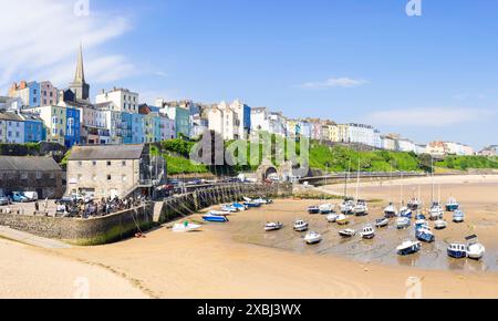 Tenby farbenfrohe Häuser oberhalb des Hafens mit kleinen Booten, die bei Ebbe im Tenby-Hafen liegen, Tenby-Carmarthan-Bucht Pembrokeshire Westwales Großbritannien GB Europa Stockfoto