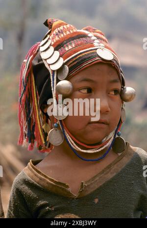 Akha Hill Tribe Indigene in Nordthailand 1995. Im Dorf Akha in Pala Akha definieren Frauen ihr Alter oder ihren Familienstand mit dem Stil des Kopfschmucks. Ein Mädchen im Alter von etwa 12 Jahren trägt eine Kindermütze, die mit nur wenigen Silbermünzen verziert ist. 1990er Jahre HOMER SYKES. Stockfoto