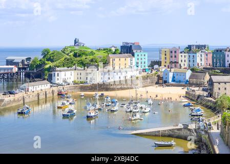 Kleine Boote in Tenby Harbour und Tenby Harbour Beach bei Flut mit Tenby farbenfrohen Häusern Tenby Carmarthan Bay Pembrokeshire West Wales UK GB Stockfoto
